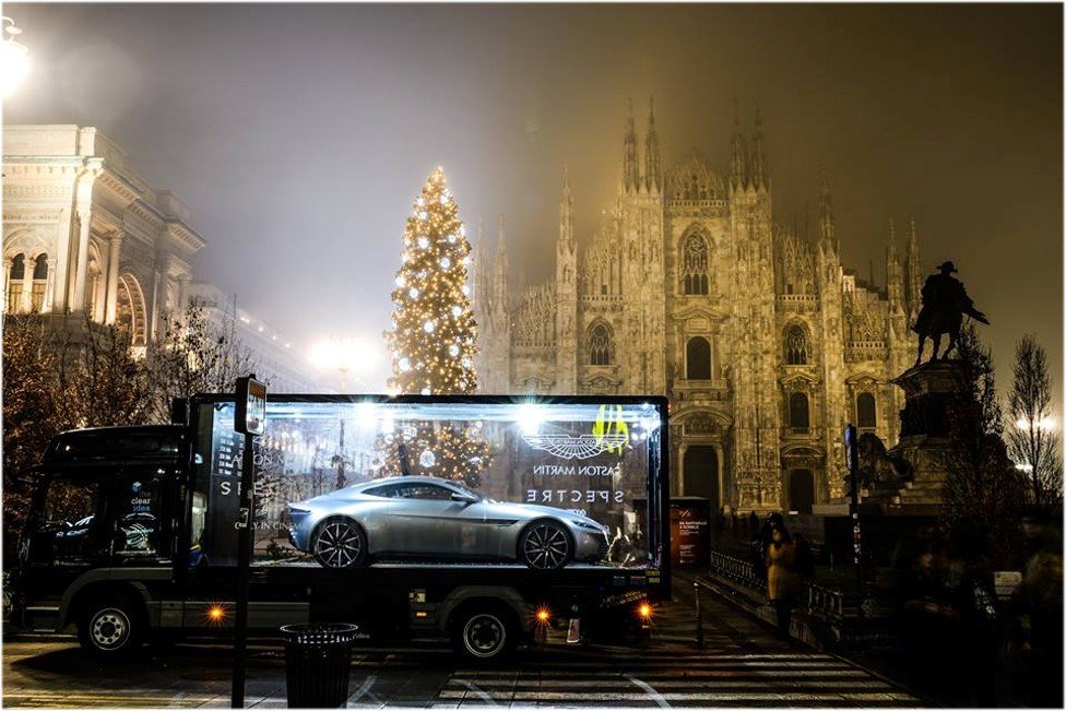 Aston Martin DB10, designed for James Bond, is showcased in a transparent exhibition truck in front of Milan's Duomo