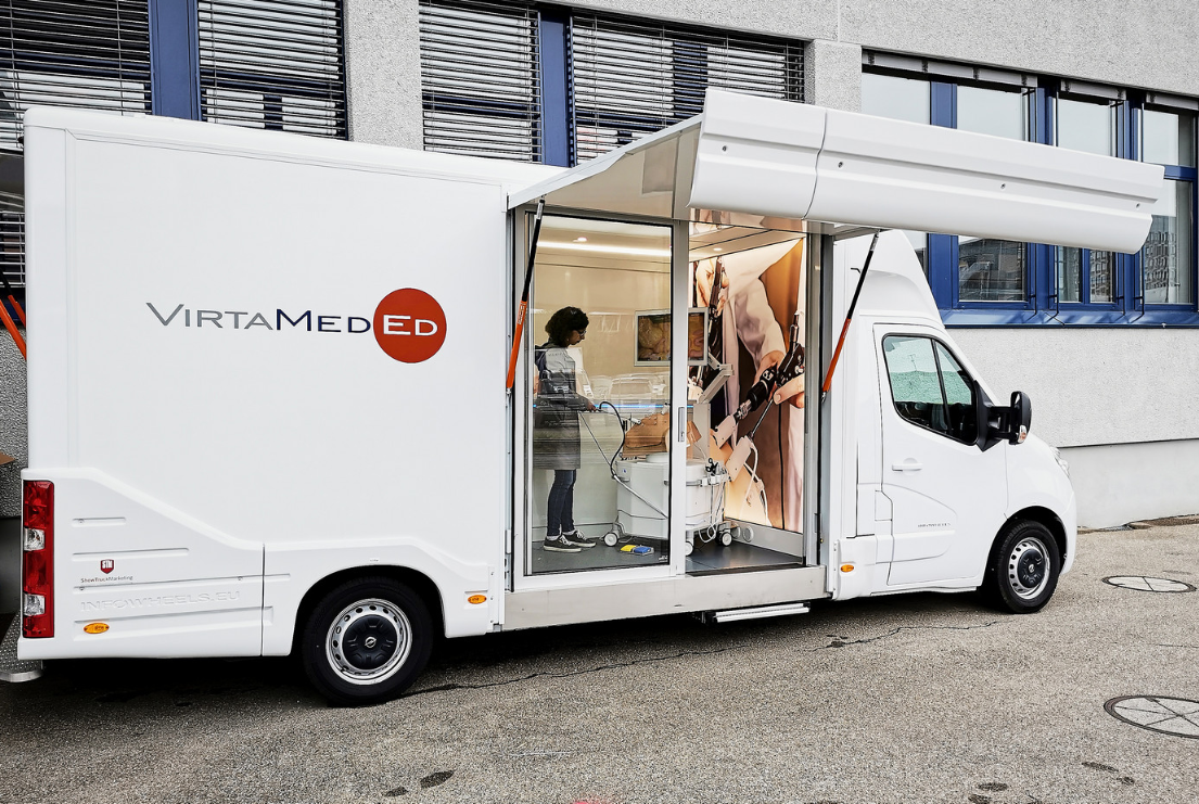 A mobile exhibition unit by VirtaMed on display, providing an interactive medical training simulation to an engaged user, combining education with cutting-edge technology on the go