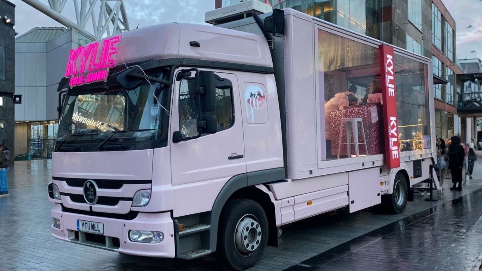 The Clear Idea Transparent Showcase Truck configured as a Kylie Cosmetics beauty roadshow vehicle with full pink vinyl wrap and neon signage at a UK city tour stop