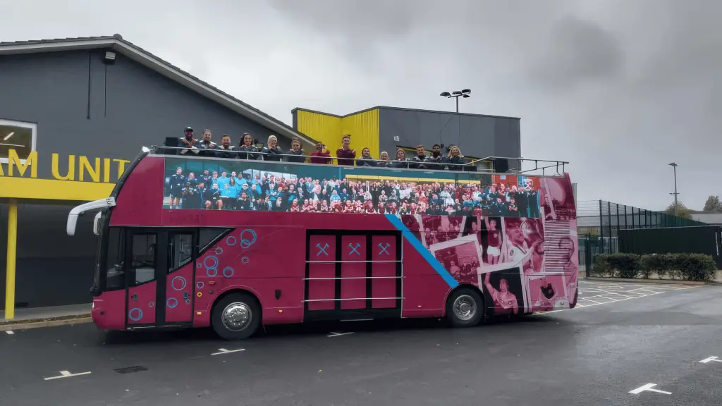 LED HyperBus promotional bus at West Ham training ground with Foundation branding LED screens and team group standing on open top deck