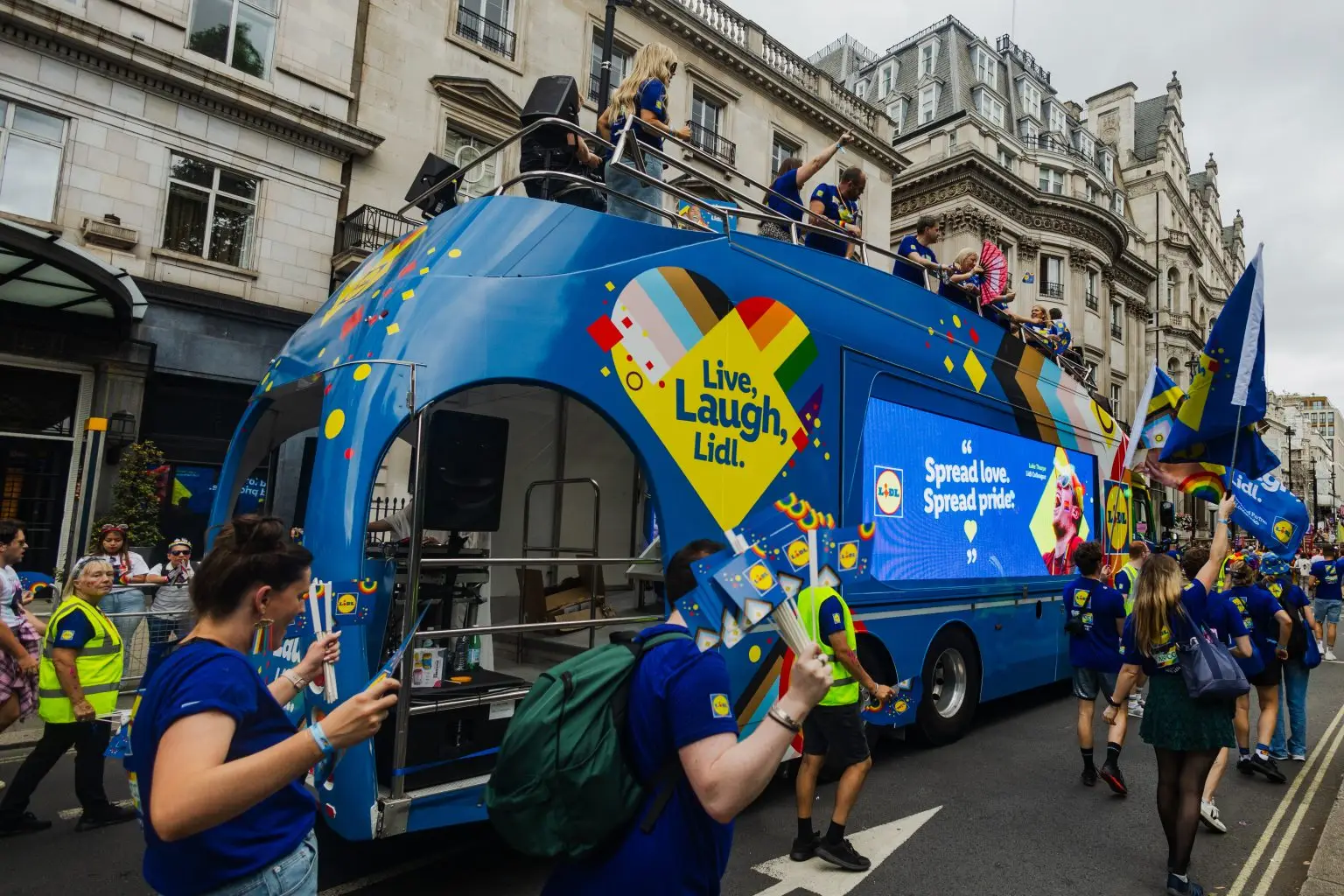 LED ShowTruck exhibition truck rear view at London Pride with Lidl and NSPCC branding performers on upper deck and London street scene