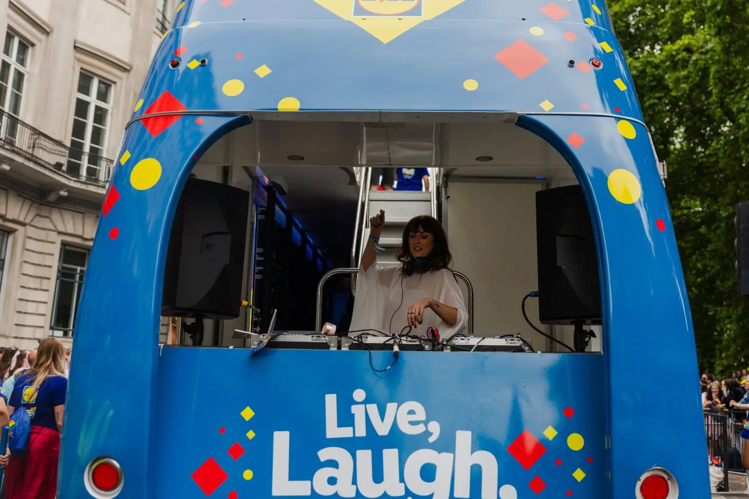 DJ performing on lower deck of LED ShowTruck exhibition truck at London Pride Lidl activation with blue branding visible