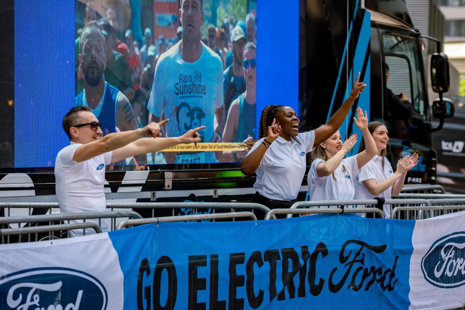 Ford brand ambassadors cheering marathon runners beside LED ShowTruck exhibition truck at London Marathon Go Electric activation