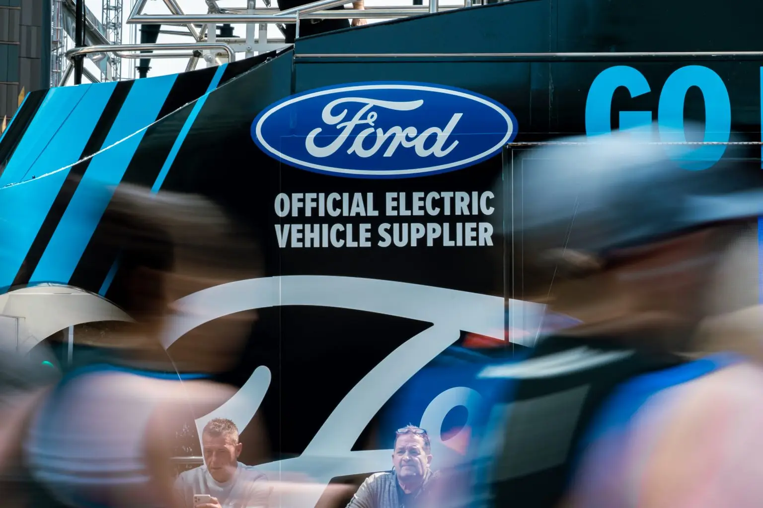 Close-up of Ford Official Electric Vehicle Supplier branding on LED ShowTruck exhibition truck with blurred runners at London Marathon