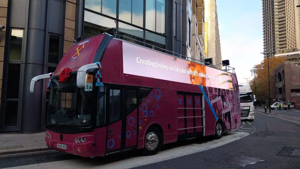 LED HyperBus promotional bus side profile in City of London with West Ham Foundation wrap and LED screen displaying social value content
