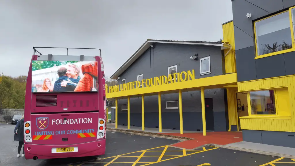 LED HyperBus promotional bus at West Ham United training ground with Foundation branding and LED screens displaying community programme content