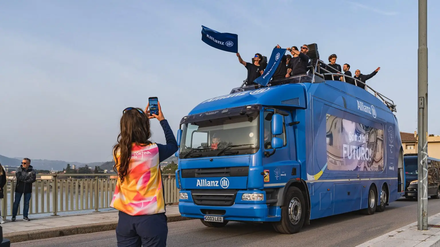 Allianz LED ShowTruck crossing a bridge during the Milano Cortina 2026 Paralympic Torch Relay