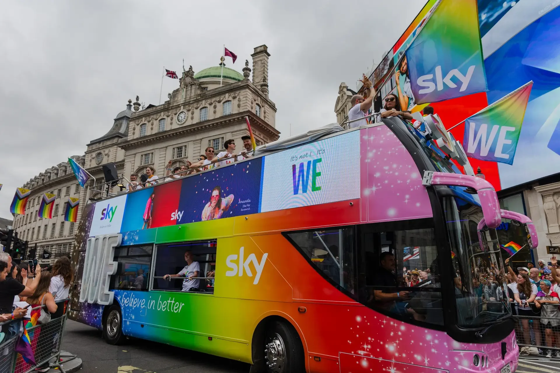 LED HyperBus promotional bus at Piccadilly Circus London Pride with Sky rainbow wrap LED screens and guests celebrating on open top deck