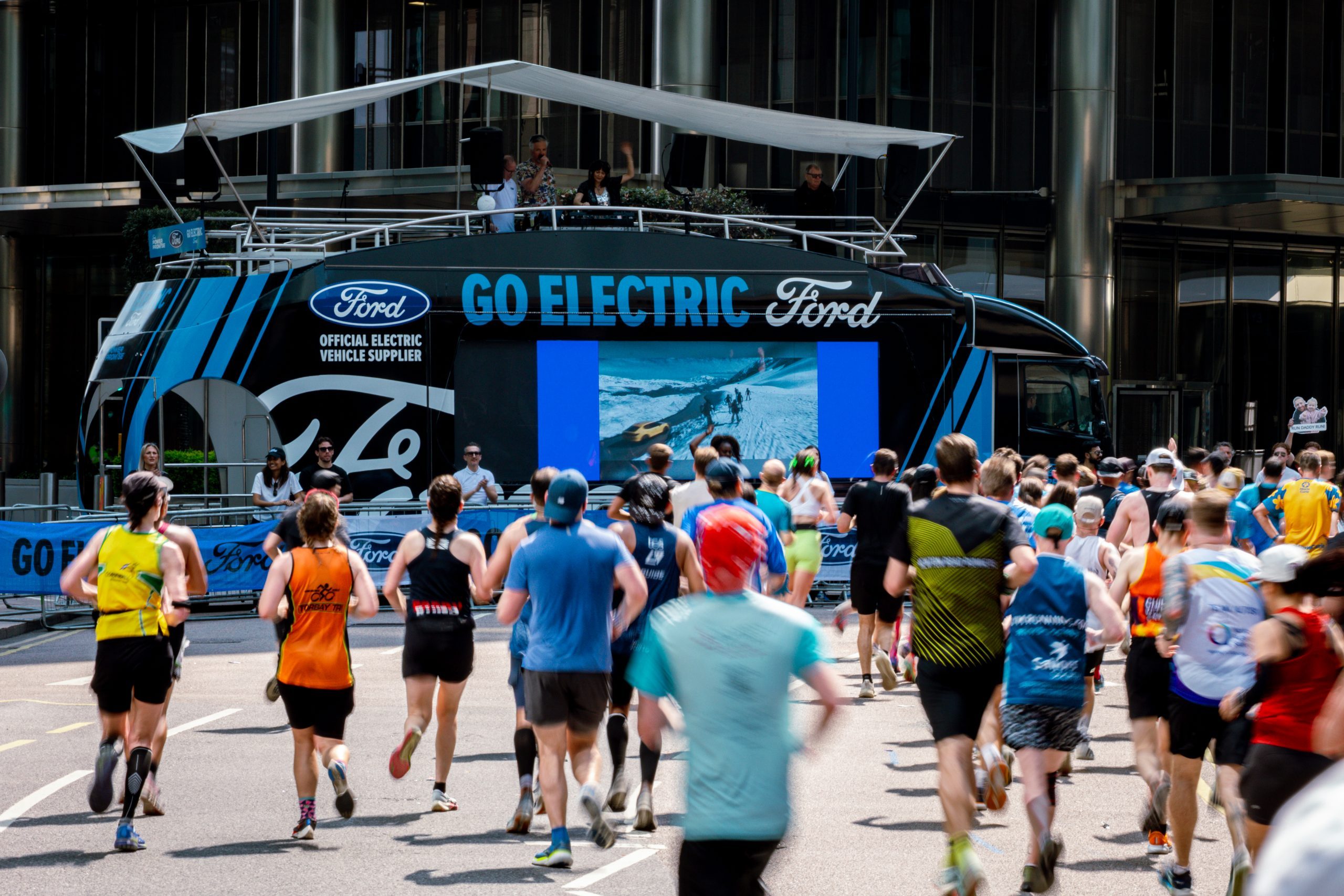 Ford Go Electric activation with LED ShowTruck by The Clear Idea at marathon event with LED screens stage canopy and runners passing
